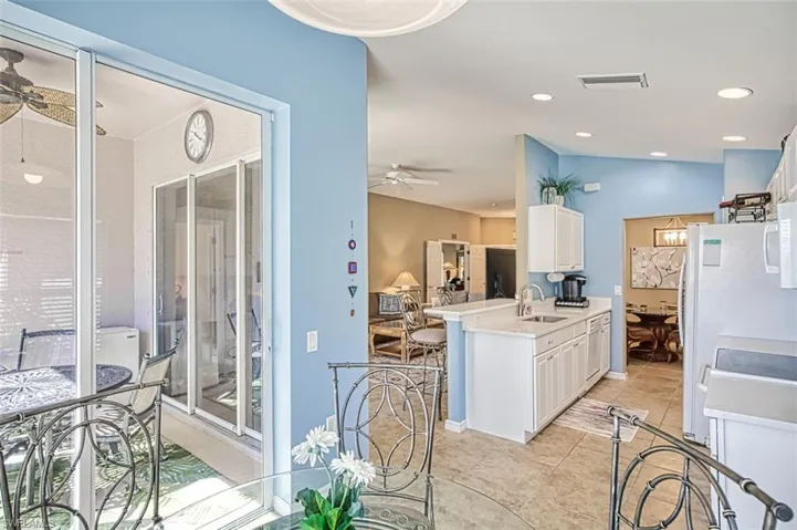 Kitchen featuring white cabinetry, a ceiling fan, recessed lighting, light tile patterned flooring, and a peninsula