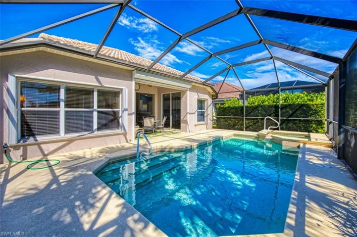 View of swimming pool featuring a sunroom, a patio area, a pool with connected hot tub, and a lanai