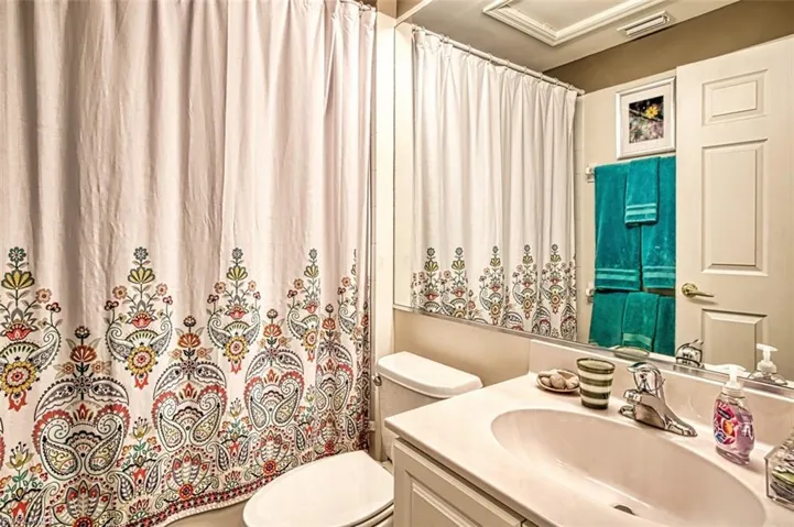 Full bathroom with vanity and curtained shower