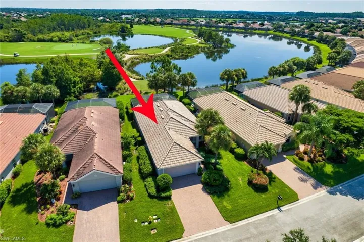 Aerial view of residential area featuring a large body of water and a local golf course