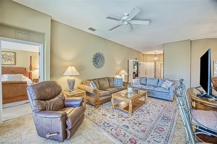 Living area featuring ceiling fan and tile patterned flooring