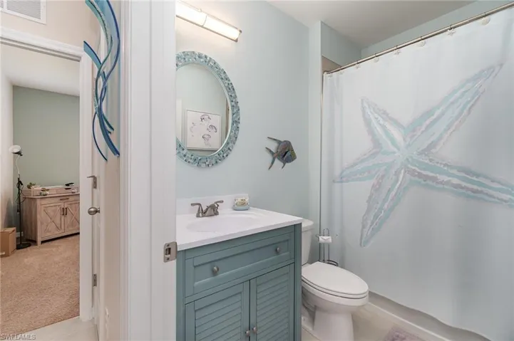 Bathroom featuring toilet, vanity, tile flooring, and shower/bath