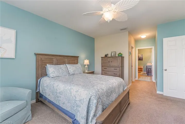 Carpeted bedroom featuring ceiling fan