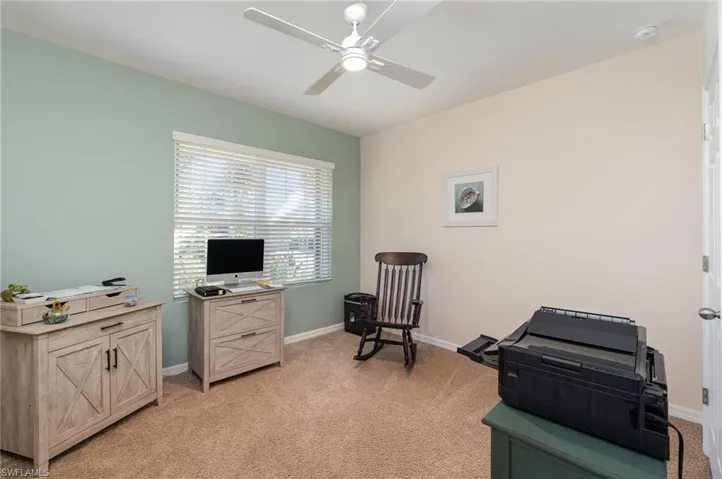 Carpeted guest room/office with ceiling fan