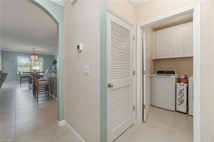 Laundry room featuring cabinets, washer and dryer, tiled floors