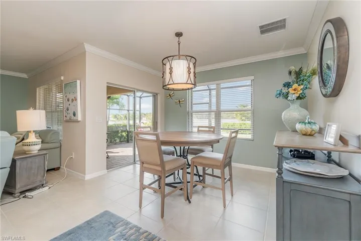 Dining space with light tile floors and crown molding