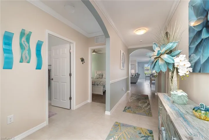 Foyer/Hallway with crown molding and light tile flooring