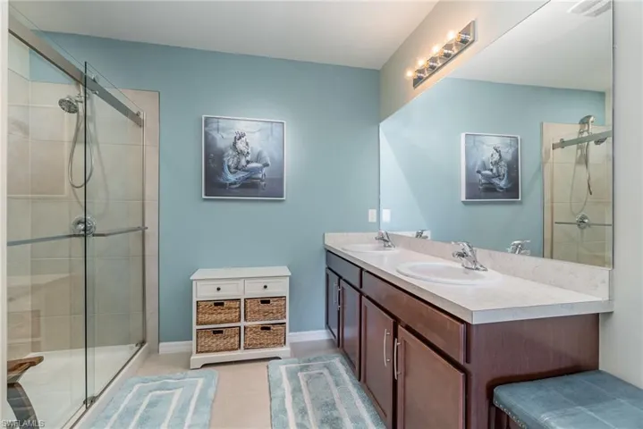 Bathroom featuring vanity, tile flooring, and a shower with door
