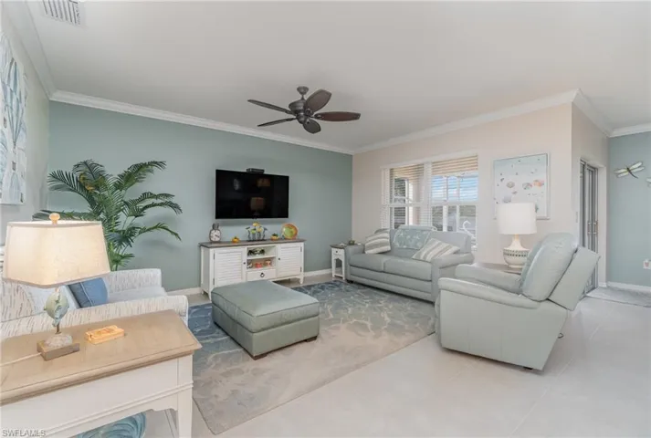 Living room featuring crown molding and ceiling fan