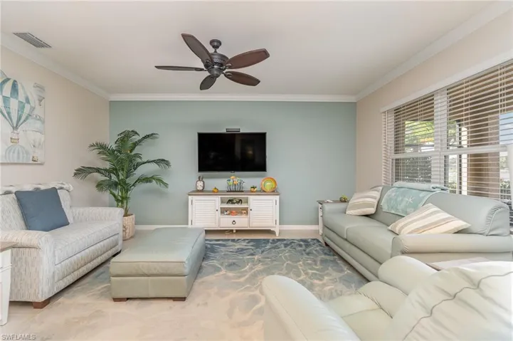 Living room featuring ceiling fan and crown molding