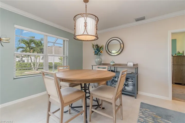 Dining space featuring light tile floors and crown molding