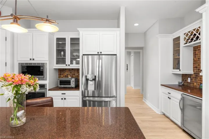 Kitchen featuring white cabinets, backsplash, and stainless steel appliances