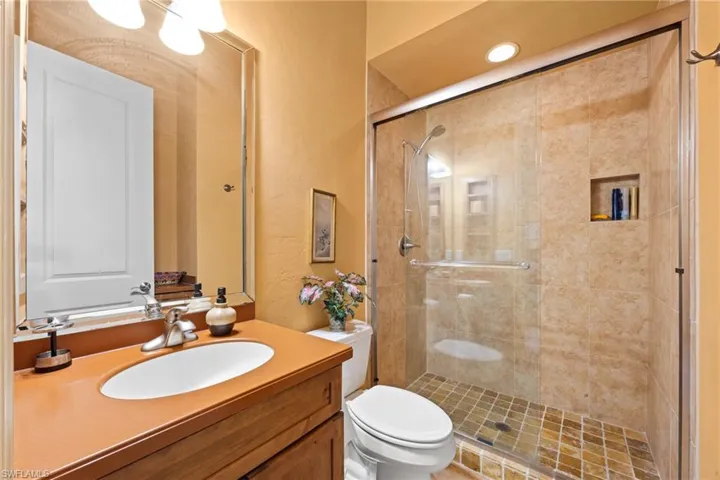 Bathroom featuring vanity, an enclosed shower, and toilet