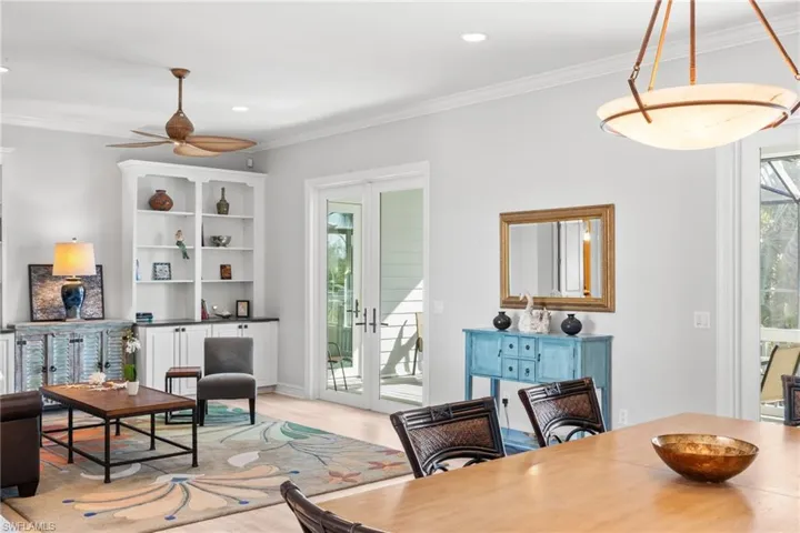 Dining area featuring crown molding, french doors, ceiling fan, and light wood-type flooring