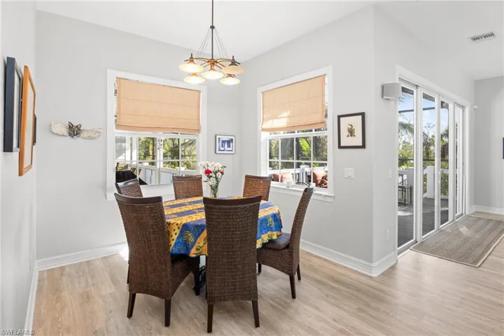 Dining space featuring a wealth of natural light, light hardwood / wood-style flooring, and a notable chandelier
