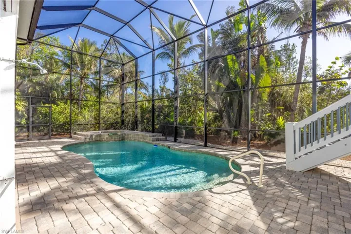 View of swimming pool with a lanai and a patio area. Remote controlled spa