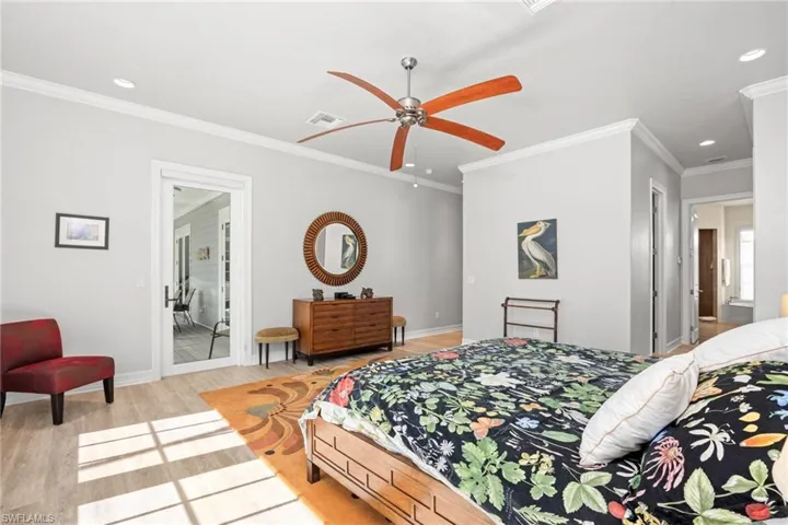 Bedroom with ceiling fan, crown molding, ensuite bathroom, and light hardwood / wood-style flooring