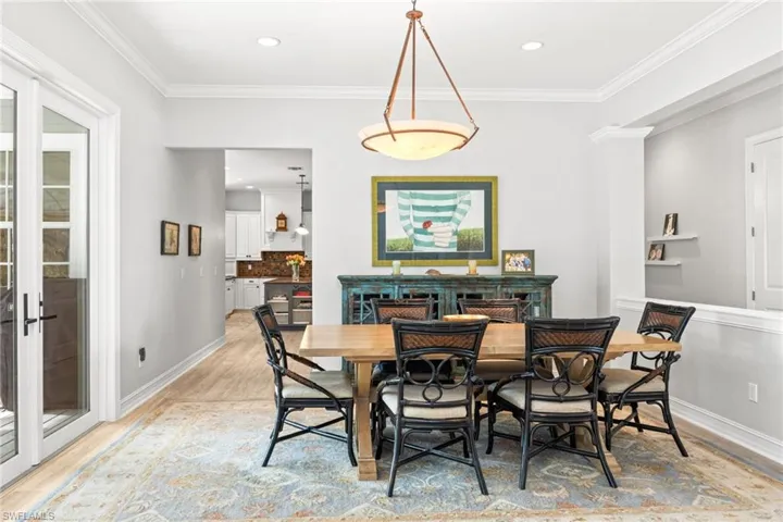 Dining room featuring french doors, light hardwood / wood-style flooring, and ornamental molding