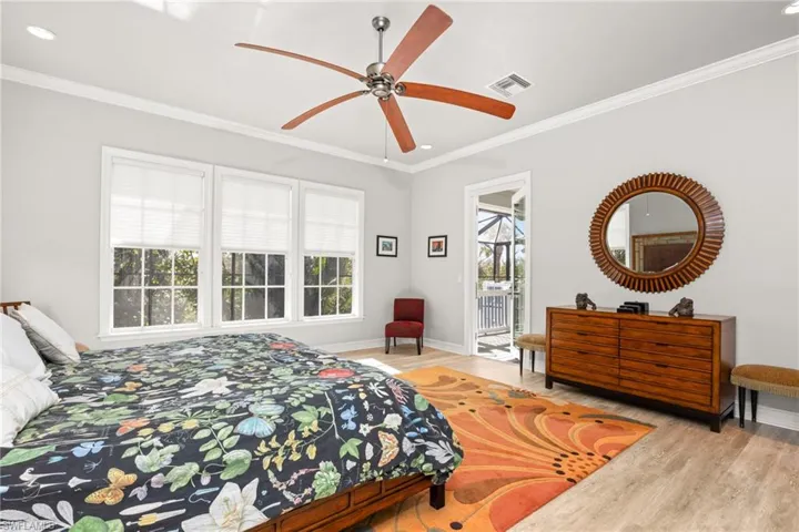 Bedroom with access to outside, light hardwood / wood-style flooring, ceiling fan, and crown molding