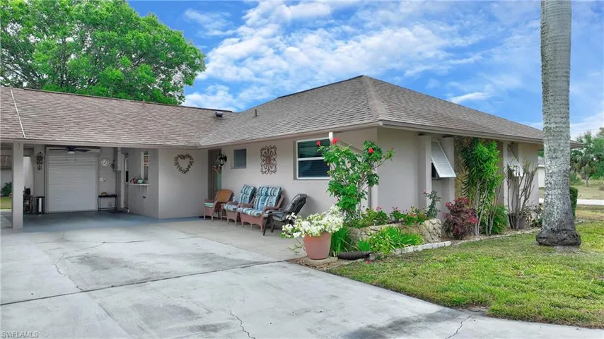 Single story home featuring a carport and a front lawn