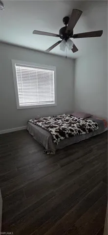 Bedroom #2 with dark wood finished floors and a ceiling fan