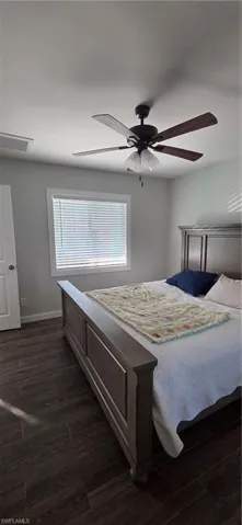 Bedroom featuring ceiling fan and dark wood-style flooring