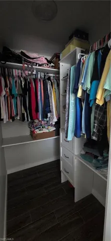 Walk in closet featuring wood finish floors