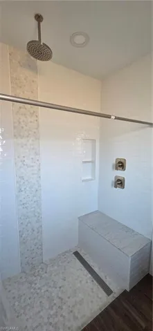 Master bath featuring a stall shower and dark wood-style flooring