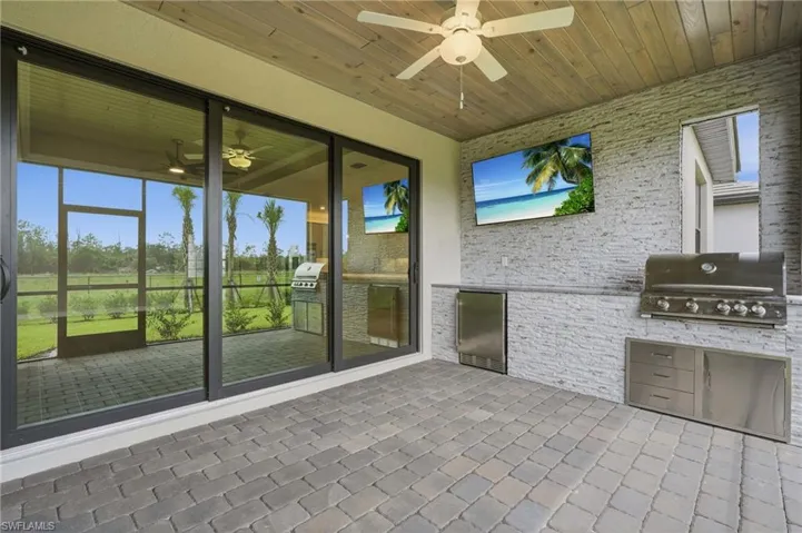 Covered outdoor living space featuring a wood-finish ceiling, ceiling fan, and paver flooring