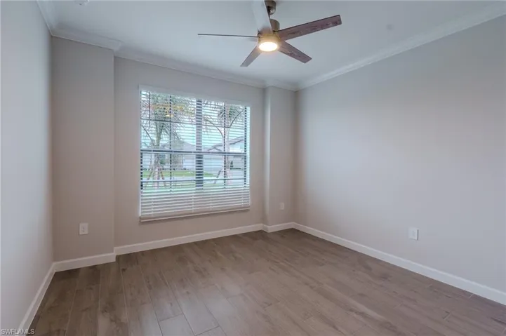 Hallway featuring wood-finish flooring, recessed lighting, and crown molding