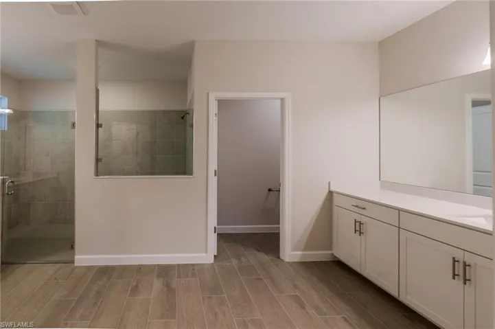 Room featuring wood-look tile flooring, crown molding, a ceiling fan with integrated lighting, and bi-fold closet doors