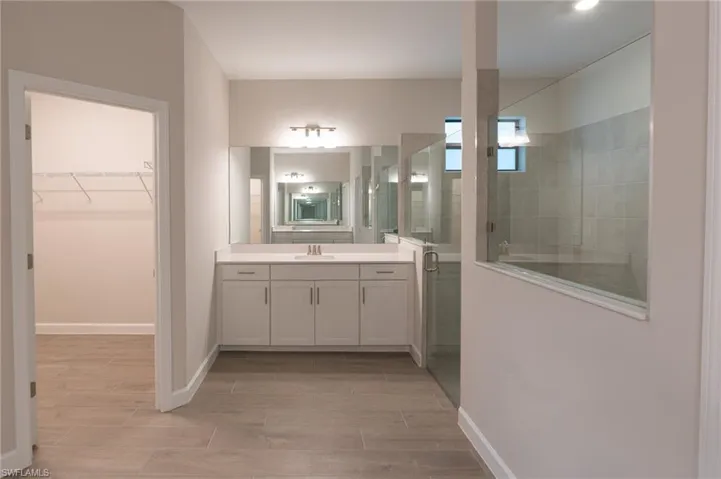 Spacious room featuring wood-finish flooring, a window with horizontal blinds, crown molding, and a modern ceiling fan with integrated lighting