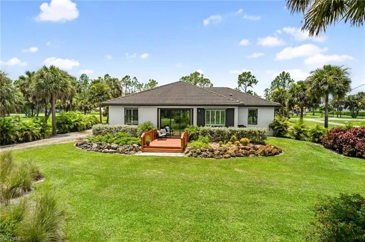 Rear view of property with a yard and a deck