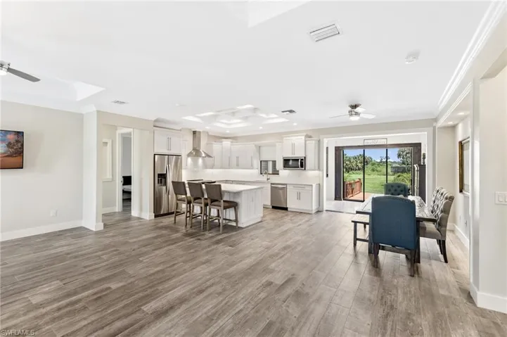Kitchen featuring light hardwood / wood-style flooring, a kitchen island, ceiling fan, a breakfast bar area, and stainless steel appliances
