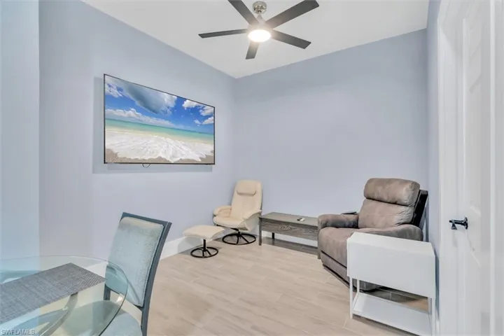 Sitting room featuring a ceiling fan, wood finished floors, and baseboards