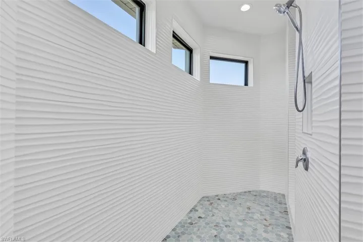 Full bathroom with tiled shower and recessed lighting