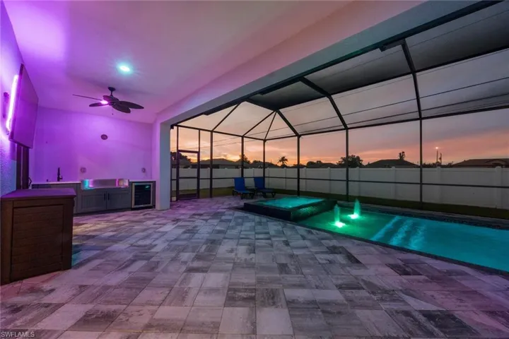 View of pool with a patio area, ceiling fan, a lanai, a pool with connected hot tub, and a sink