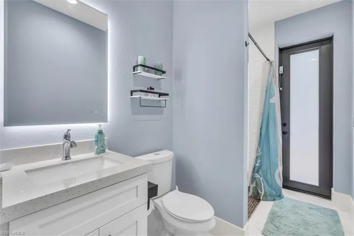 Full bath with toilet, a shower with shower curtain, and vanity