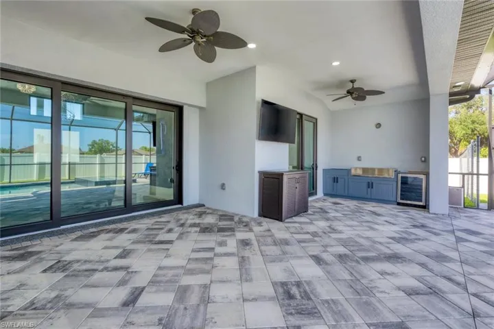 View of patio featuring ceiling fan, beverage cooler, and an outdoor kitchen