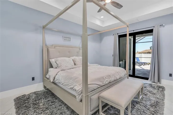 Bedroom featuring access to outside, baseboards, ceiling fan, a raised ceiling, and recessed lighting