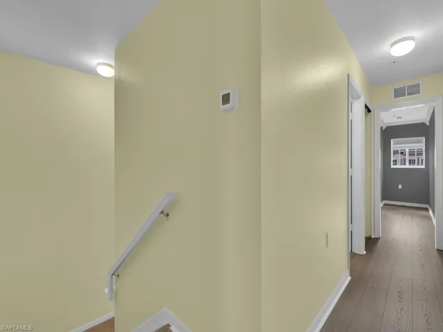 Corridor featuring baseboards and dark wood-style flooring