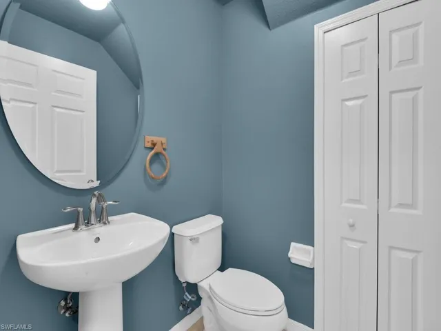 Half bath featuring toilet and a closet