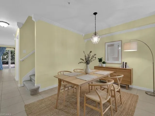 Dining room featuring crown molding, light tile patterned floors, and hanging lights