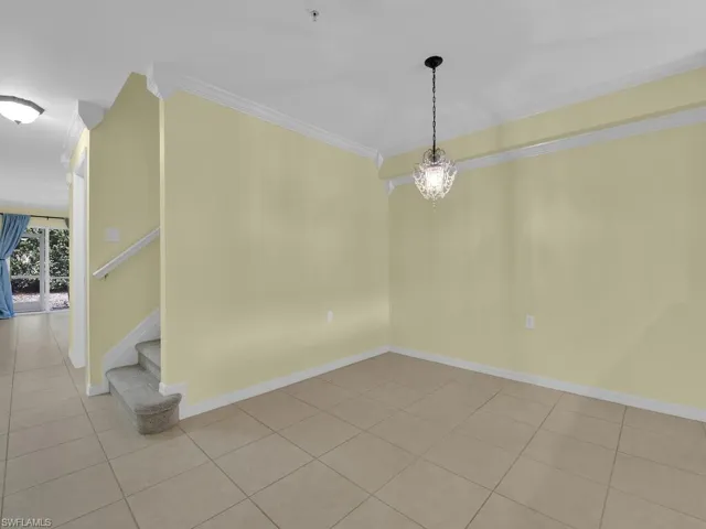 Unfurnished room with crown molding, suspended lighting, and light tile patterned floors