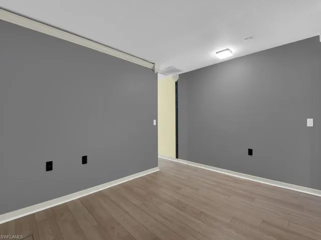 Spare room with light wood-style floors and crown molding