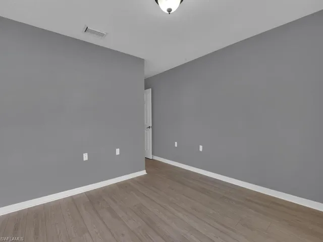 Spare room with baseboards and light wood finished floors