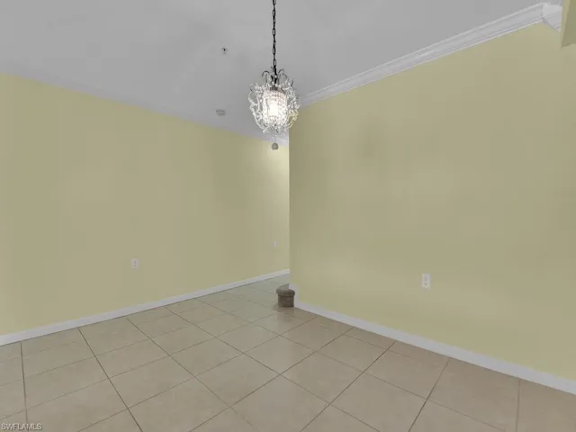 Unfurnished room featuring ornamental molding, a chandelier, and light tile patterned flooring