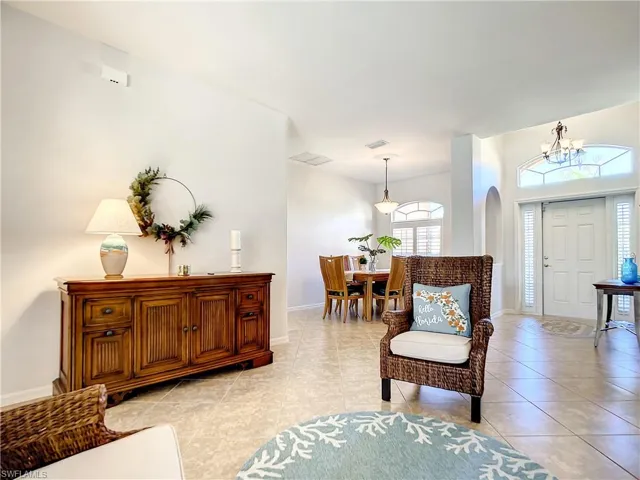 Great room with decorative flooring on a diagonal looking at foyer and formal dining area