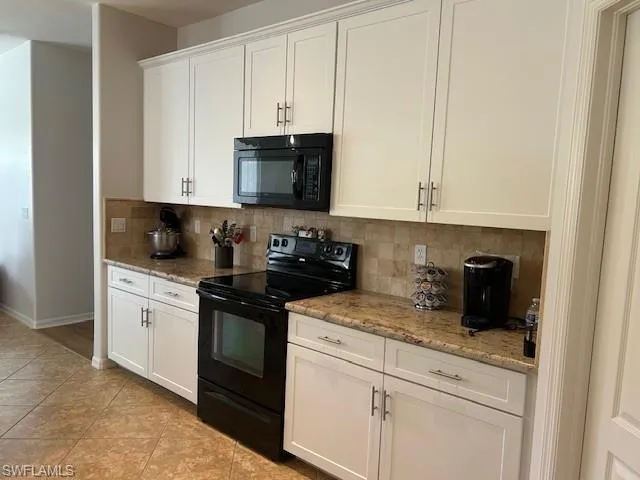 Bright kitchen with granite countertops, breakfast bar and pendant lights