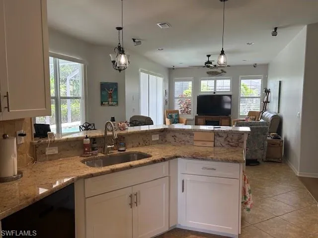 Kitchen with decorative backsplash, a peninsula, white cabinetry, and recessed lighting